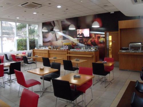 a restaurant with tables and chairs and a bar at ibis Jaboticabal in Jaboticabal