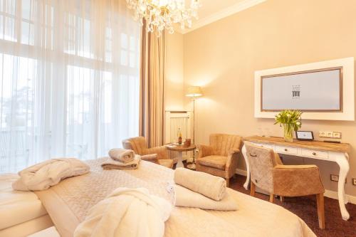 a hotel room with a bed and a desk and a room at Hotel Vier Jahreszeiten Binz in Binz