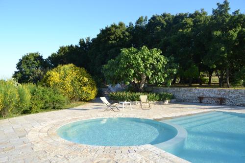a swimming pool with a table and chairs in a yard at B&B Corte Del Camedrio in Cisternino