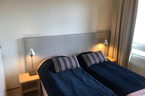 1 dormitorio con 1 cama azul y 2 almohadas en Tahko Chalet B 601, en Tahkovuori