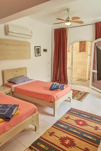 a bedroom with two beds and a ceiling fan at Solaris in Dahab