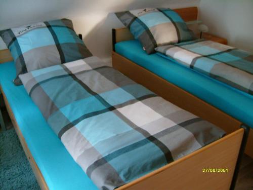 2 Einzelbetten in einem Zimmer in Blau in der Unterkunft Ferienwohnung Lange in Bergen