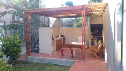 a wooden pergola with a table in a kitchen at Las Casuarinas in Pilar