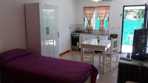 a bedroom with a bed and a table and a kitchen at Las Casuarinas in Pilar
