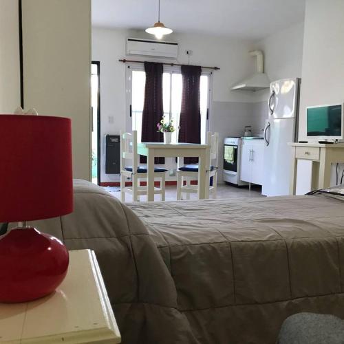 a bedroom with a bed and a kitchen with a table at Las Casuarinas in Pilar