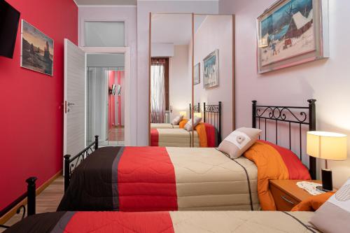1 dormitorio con 2 camas y pared roja en Nico&Cinzia Apartments, en Milán