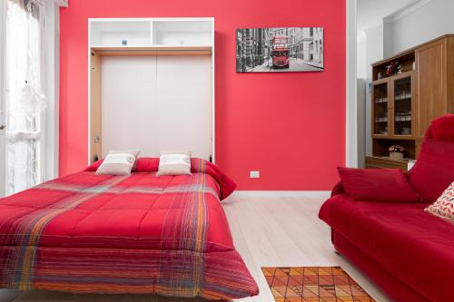 Dormitorio rojo con cama y sofá en Nico&Cinzia Apartments, en Milán