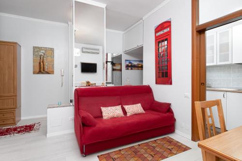 a red couch in a room with a kitchen at Nico&Cinzia Apartments in Milan