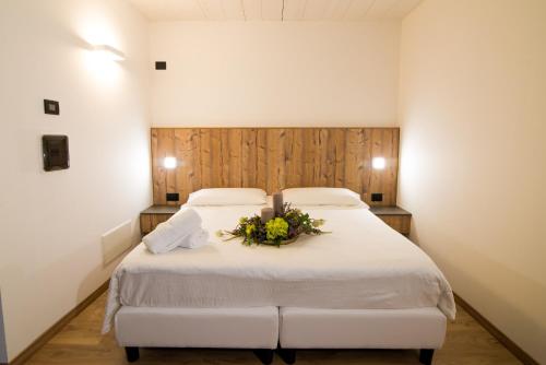 a bedroom with a white bed with flowers on it at Hotel Alla Fonte in Arta Terme