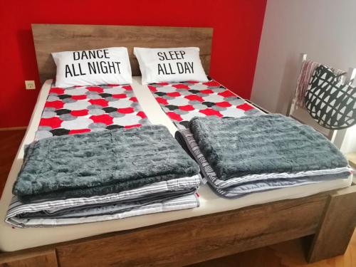 a bed with blankets and pillows on top of it at Apartman Red wall in Čačak