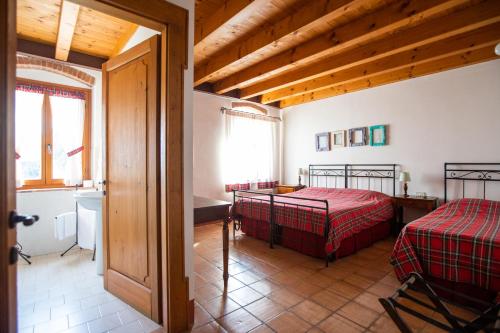 a bedroom with two beds in a room with wooden ceilings at Agriturismo Ca' Vecia in Castelnuovo del Garda