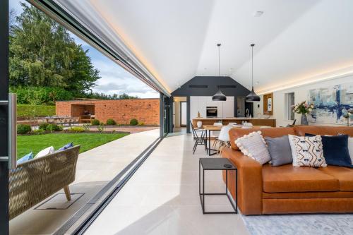 an open living room with a couch and a table at The Barn : Luxury Indoor/Outdoor Countryside Bliss in Clipston