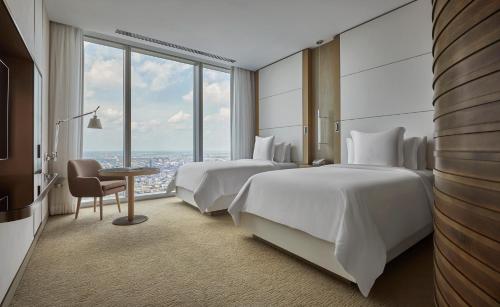 um quarto de hotel com duas camas e uma mesa com uma cadeira em Four Seasons Hotel Philadelphia at Comcast Center em Filadélfia