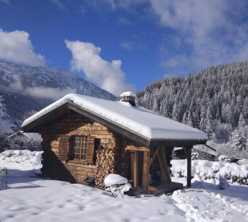 ein Blockhaus mit Schnee darüber in der Unterkunft Chalet Le Marmouzet in Les Houches