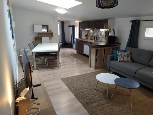 a living room and kitchen with a couch and a table at La perle du 58 - T2 Parking Wifi Terrasse CLIM in Rodez