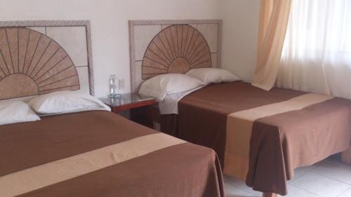 a hotel room with two beds and a window at Hotel Albatros Palace in Manzanillo