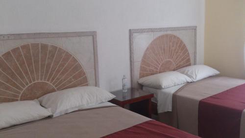 a room with two beds and a table and two bedsskirts at Hotel Albatros Palace in Manzanillo