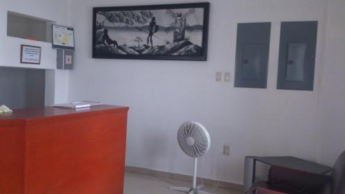 a room with a desk and a fan on a wall at Hotel Albatros Palace in Manzanillo