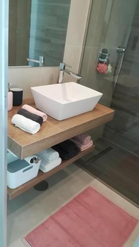 a bathroom with a white sink on a wooden shelf at Oasis Beach X 106 in Guardamar del Segura