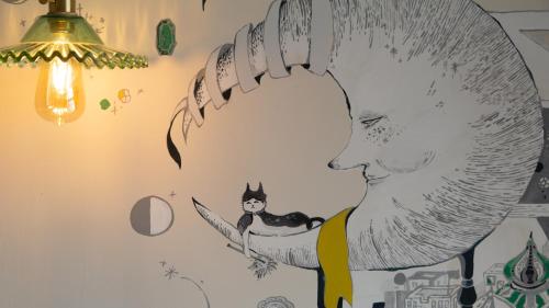a drawing of a boy with a cat on a wall at Red Letter Day in Tainan