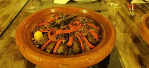 un tazón de comida con zanahorias y verduras en una mesa en Riad Tchina en Marrakech
