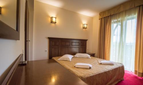 a bedroom with a bed with two towels on it at Hanul Bran in Bran