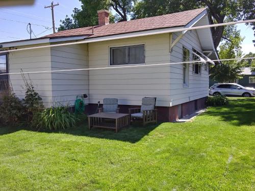 a house with two chairs and a table in the yard at Cozy and Comfortable Powell Apartment in Powell