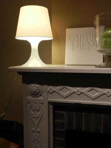 a table with a lamp on top of a fireplace at Apartment Het Blekershuys in Bruges