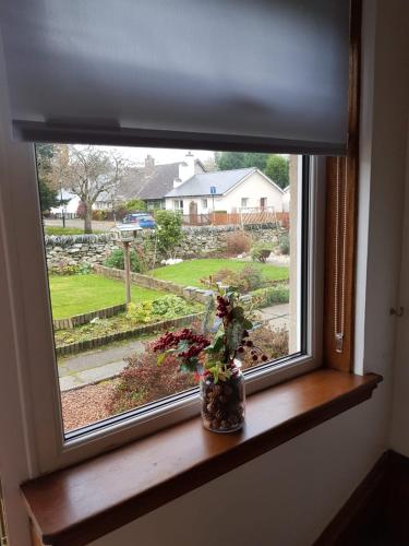 a window with a vase of flowers on a window sill at Fab-u-Luss in Luss