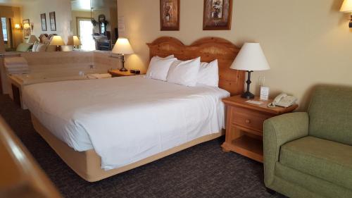 a hotel room with a bed and a chair and a phone at Homestead Suites - Fish Creek in Fish Creek