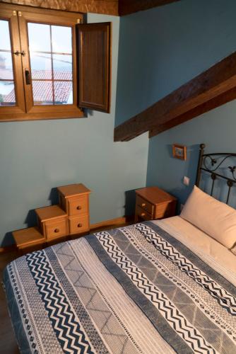 a bedroom with a bed and two windows at Apartamentos Carmen de Castro in Comillas