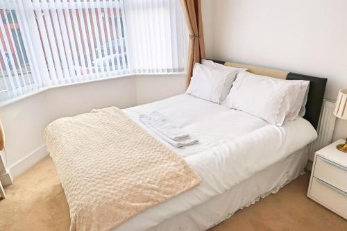 a small bedroom with a bed with white sheets and pillows at Whitburn Guest House About 7 mins Walk To The City Free Internet TV in Doncaster