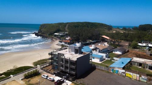 an aerial view of a beach with buildings and cars at BALUARTE POUSADA in Torres
