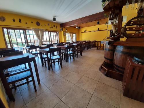 a restaurant with wooden tables and chairs and yellow walls at Hotel Vireo in Villa Gesell