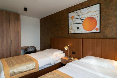 a hotel room with two beds and a painting on the wall at VIPo Prestige Apartments in Podstrana