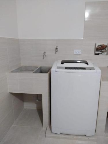 a white kitchen with a sink and a stove at J79 Apartamentos - Cerca al Parque Deportivo -Pista BMX- Pista Patinaje Velocidad - Coliseo Mayor - Complejo Acuático - Estadio Alterno in Ibagué