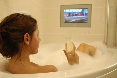 a woman sitting in a bath tub holding a glass of wine at The Seaview Hotel And Restaurant in Seaview