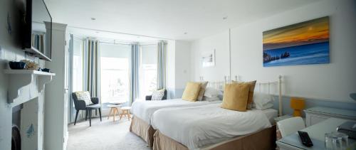 a hotel room with two beds and a table and chairs at The Seaview Hotel And Restaurant in Seaview