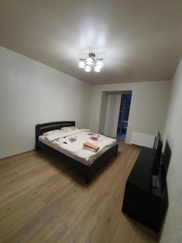 um quarto com uma cama num quarto com pisos em madeira em Яровиця. Центр em Lutsʼk