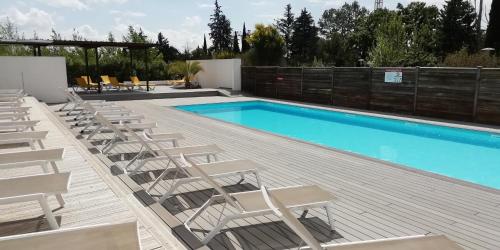 a deck with chairs and a swimming pool at Sweet Home studio Aix en Pce, clim,terrasse,piscine,pkg,resto in Aix-en-Provence
