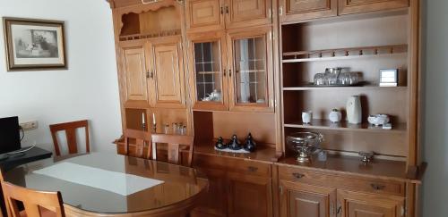 Una cocina con gabinetes de madera y una mesa de madera. en Casa Gazquez, en Santo Tomé