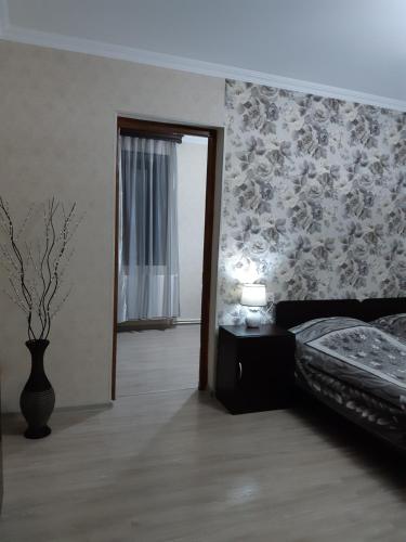 a bedroom with a bed and a flower patterned wall at Nick&David INN in Borjomi