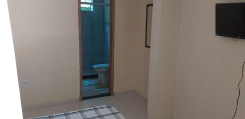 Habitación con baño con aseo y espejo. en Pousada Alto de Junqueira en Mangaratiba