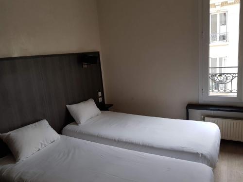 ルヴァロワ・ペレにあるホテル ドンジュのベッドルーム1室(ベッド2台、窓付)