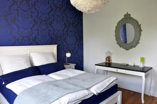 Un dormitorio con una cama azul y blanca y un espejo en Maison Elise & Philipp en Wiesbaden