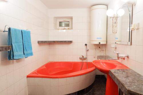 Sławatycze的住宿－NOCLEGI JOLISŁAWA，白色瓷砖浴室内的红色浴缸