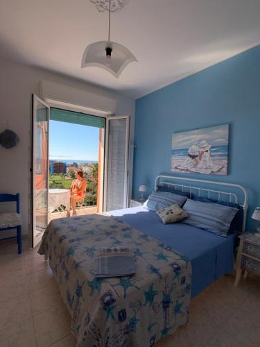 a bedroom with a bed with a blue wall at Very cosy house with fabulous sea view! in Pietra Ligure