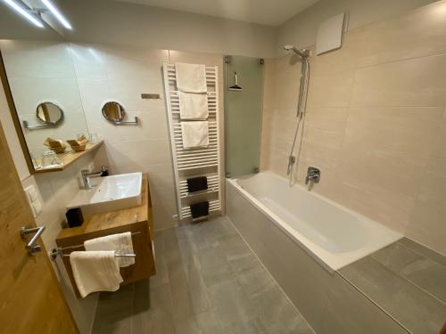 a bathroom with a tub and a sink and a shower at Alpenperle in Obsteig