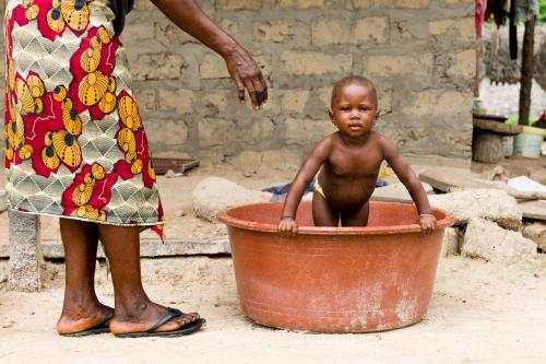 a little baby sitting in a large pot at Tamba Kuruba Eco-lodge in Folonko