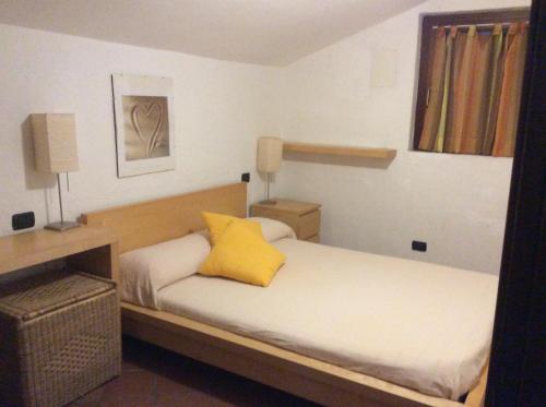 - une chambre avec 2 lits et un oreiller jaune dans l'établissement Villa Bea, à Chia